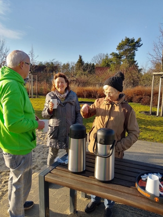 Zwei Frauen und ein Mann beim Kaffee trinken